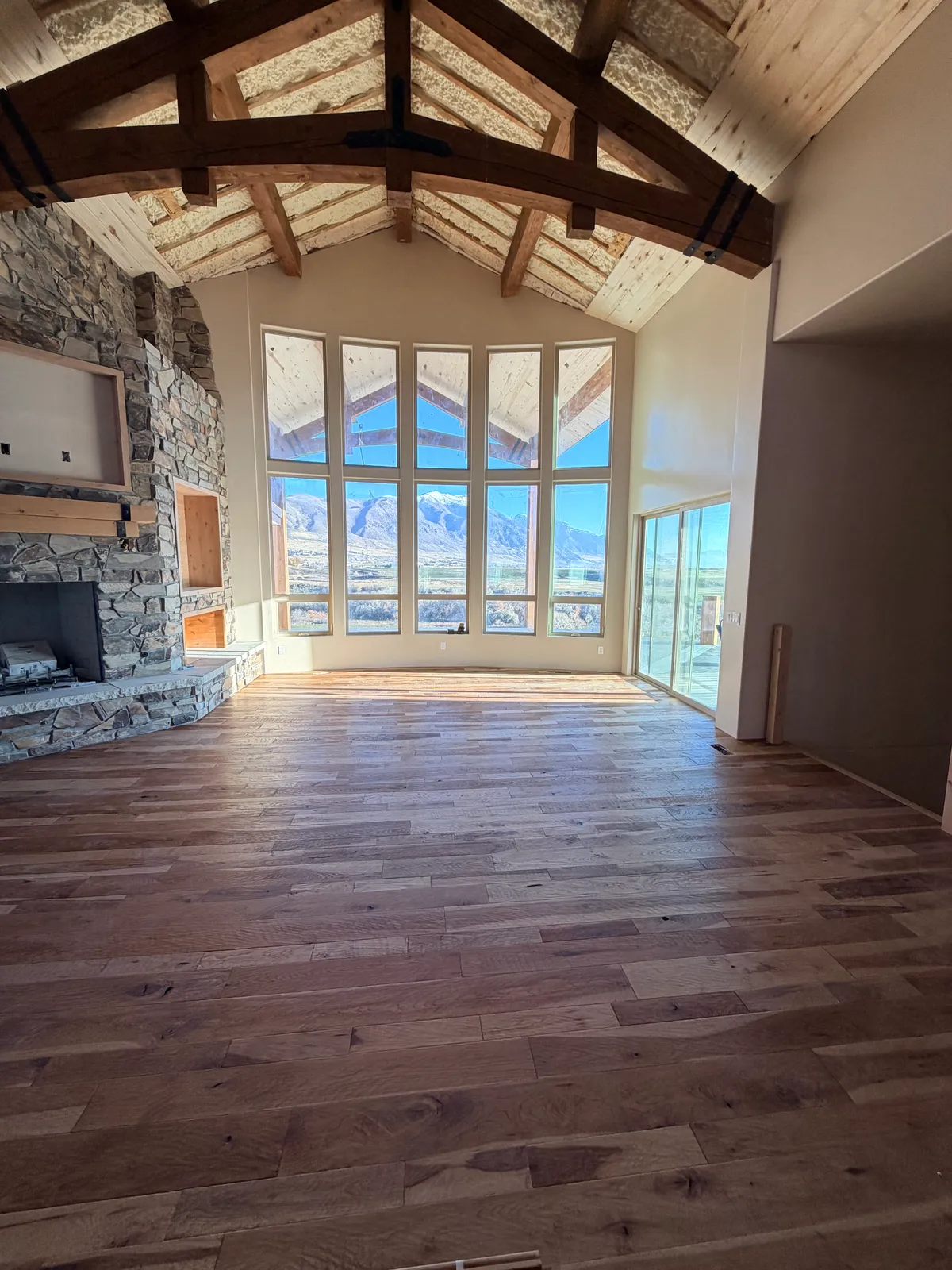 Vaulted great room with stone fireplace and hardwood floors, mountain views, Cottonwood Heights, UT