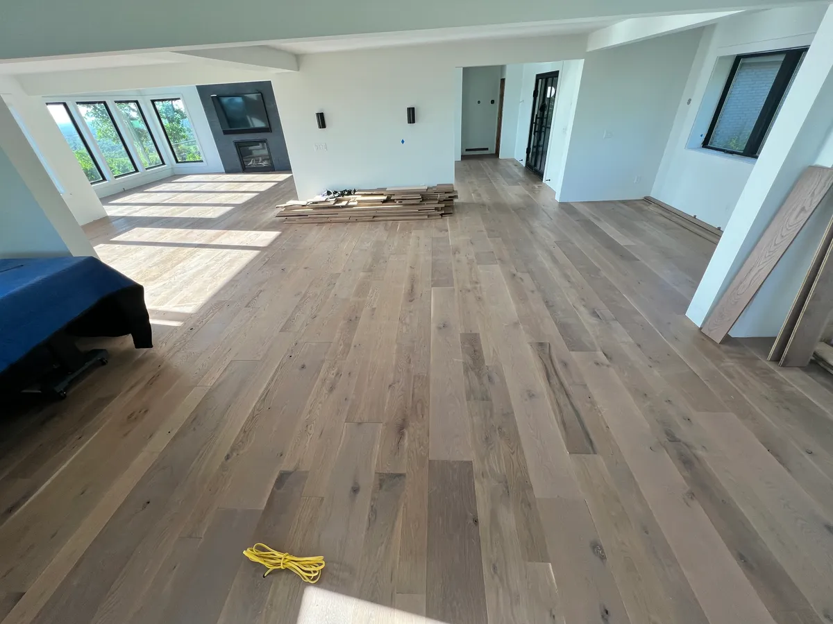 Mid-installation hardwood flooring with planks stacked